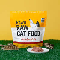 Load image into Gallery viewer, RAWR Cat Sliders Chicken 2.5lb bag on green grass with chicken meal in a dish, highlighting premium raw cat food.