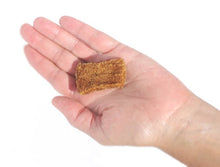 Load image into Gallery viewer, A hand holding a soft, textured Plato Real Strip Duck treat, showcasing its perfect portion size.